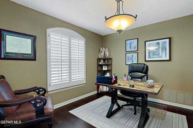 home office with wood finished floors, visible vents, and baseboards