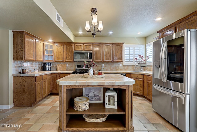 kitchen featuring open shelves, tile counters, visible vents, and appliances with stainless steel finishes