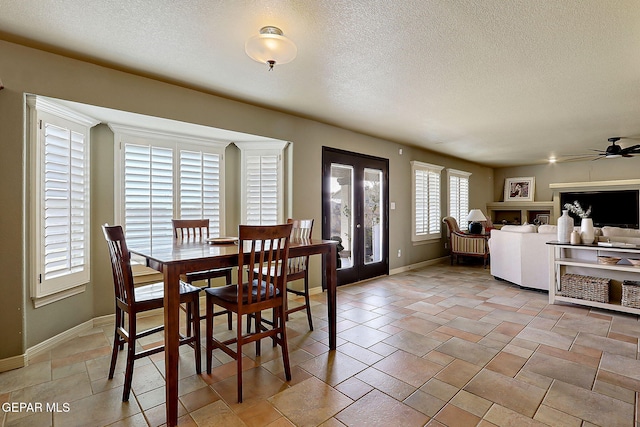 dining area with stone finish flooring, a textured ceiling, french doors, baseboards, and ceiling fan