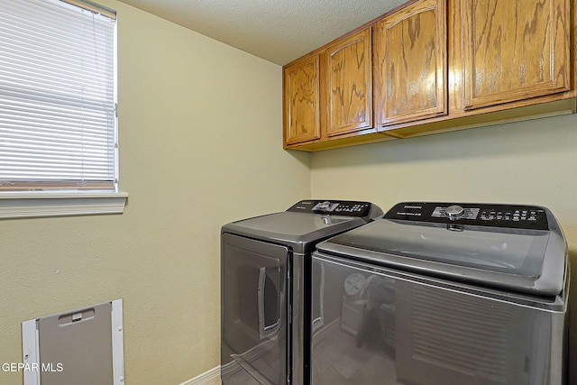 laundry room featuring cabinet space, separate washer and dryer, and a textured ceiling