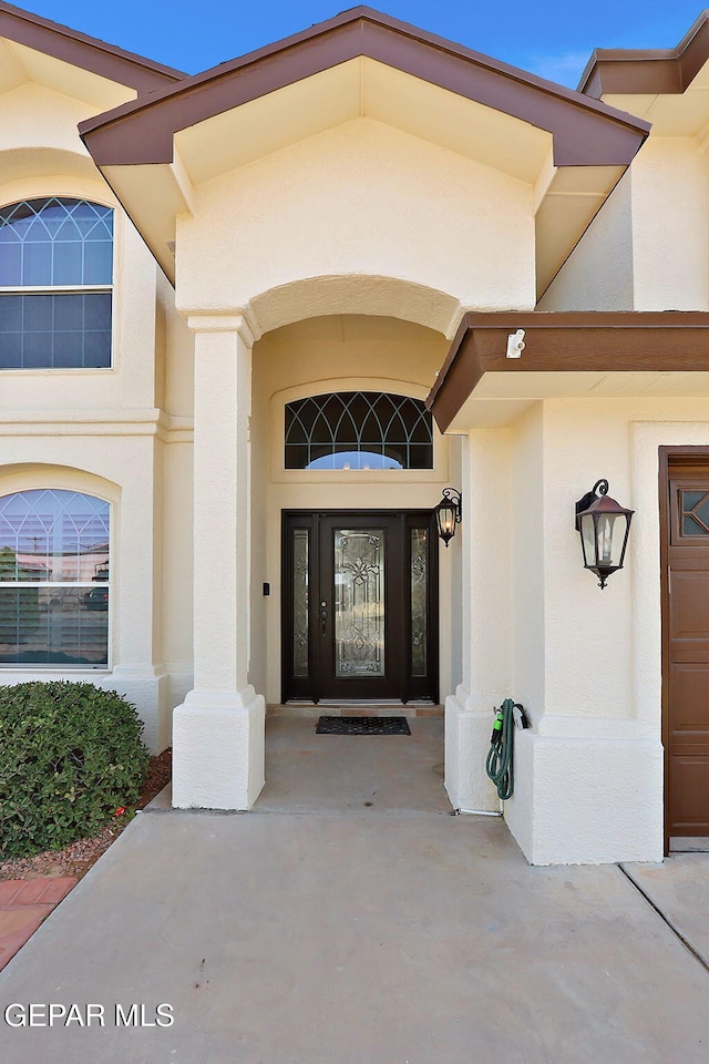 doorway to property featuring stucco siding