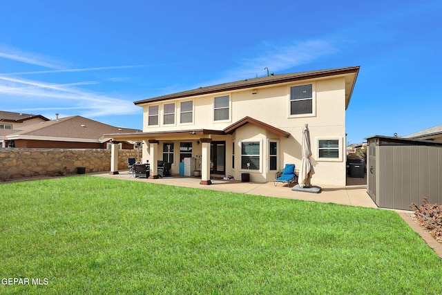 back of property featuring stucco siding, a patio, a shed, a yard, and an outdoor structure