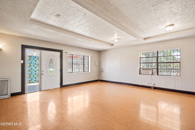 foyer entrance featuring plenty of natural light, a textured ceiling, and wood finished floors