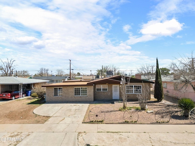 view of front facade with fence, brick siding, and driveway