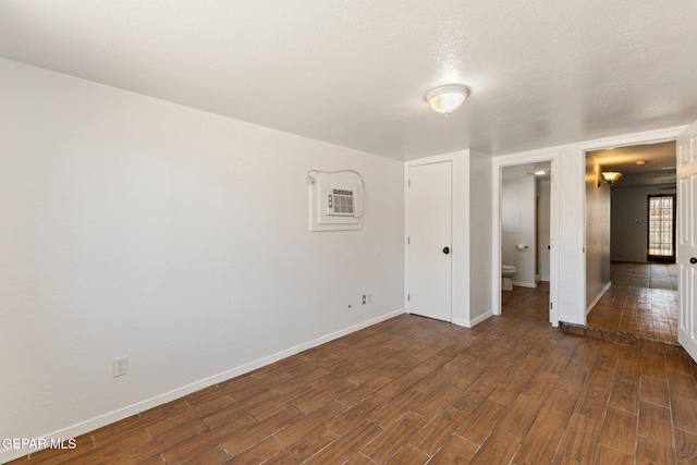 unfurnished room with dark wood finished floors and baseboards