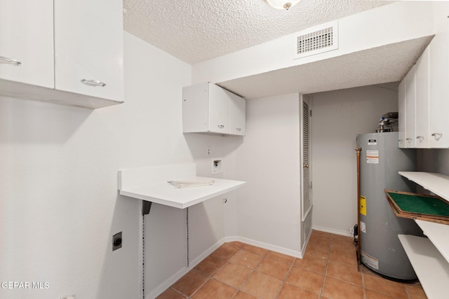 washroom with visible vents, hookup for an electric dryer, cabinet space, washer hookup, and gas water heater