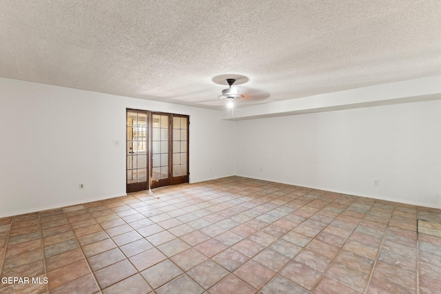 empty room with light tile patterned flooring, a ceiling fan, baseboards, and a textured ceiling