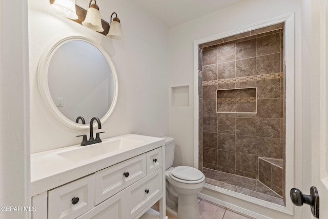 bathroom featuring a tile shower, tile patterned floors, toilet, and vanity