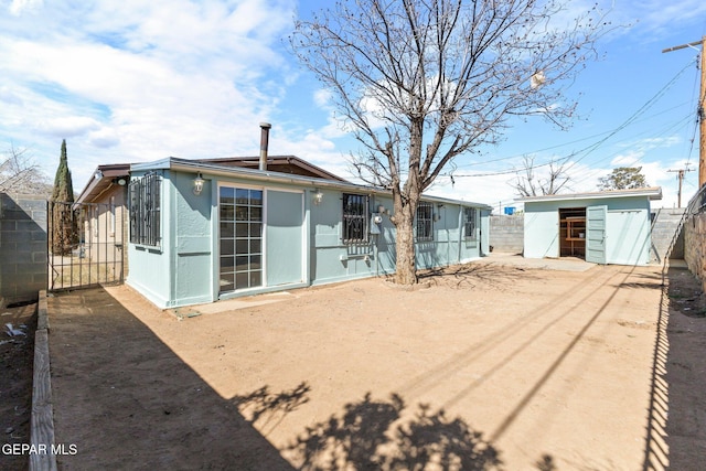 rear view of property with an outbuilding and fence