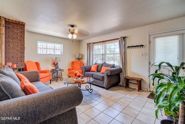 living room with light tile patterned floors, plenty of natural light, a textured ceiling, and a ceiling fan