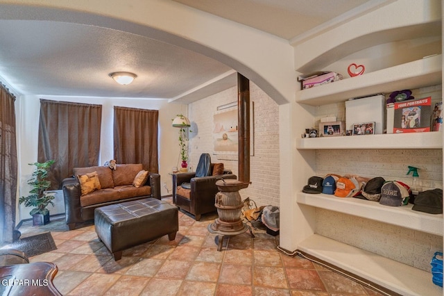 living area featuring arched walkways and a textured ceiling