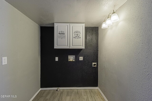 interior space featuring light wood-type flooring, baseboards, washer hookup, and a textured ceiling