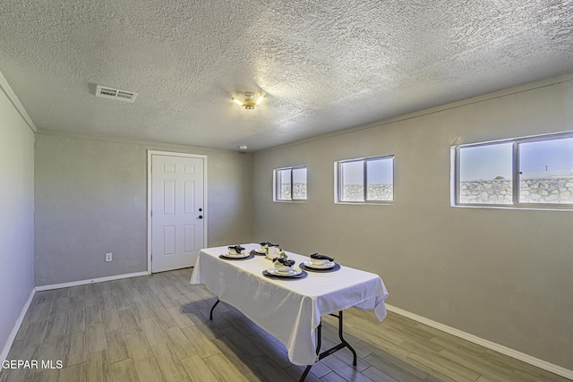 dining space with baseboards, visible vents, and light wood-style floors