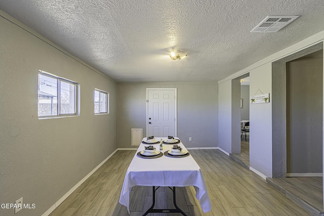 dining room featuring light wood-style floors, visible vents, and baseboards