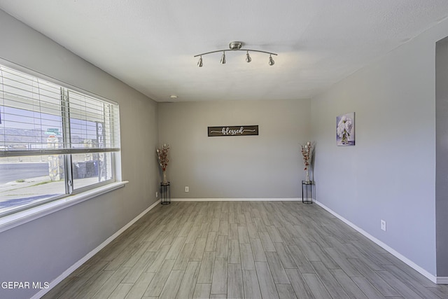 unfurnished room with wood finished floors and baseboards