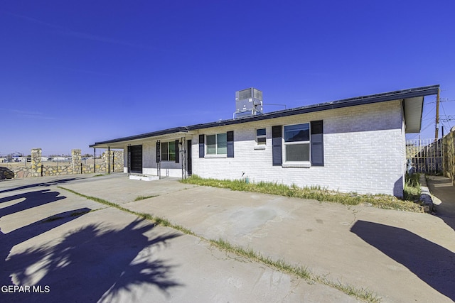 view of front of property with central AC and brick siding