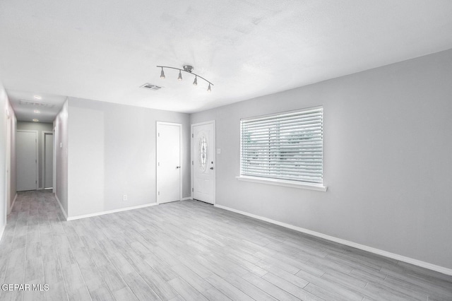 unfurnished room featuring visible vents, baseboards, and wood finished floors