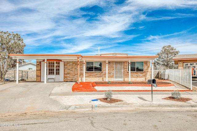 ranch-style house with an attached carport, brick siding, and fence