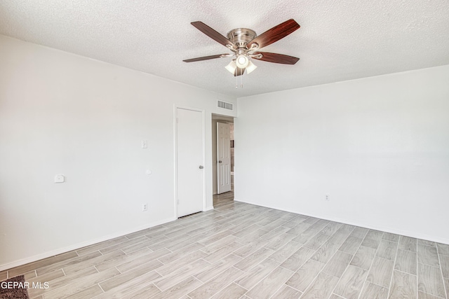 unfurnished room featuring light wood finished floors, visible vents, a ceiling fan, a textured ceiling, and baseboards