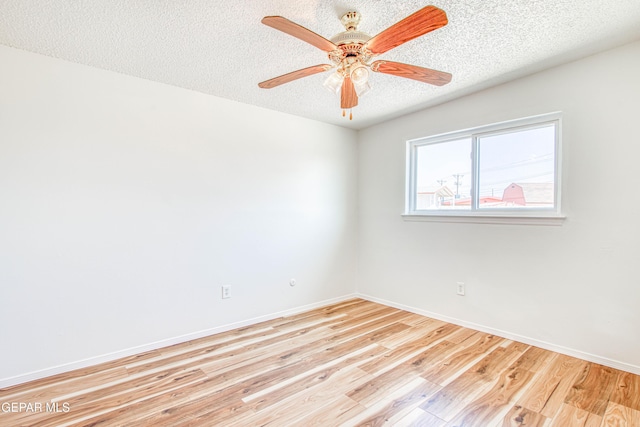 unfurnished room featuring light wood-type flooring, ceiling fan, baseboards, and a textured ceiling