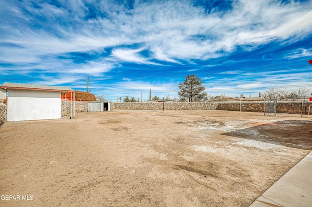 view of yard with an outbuilding, a shed, and fence