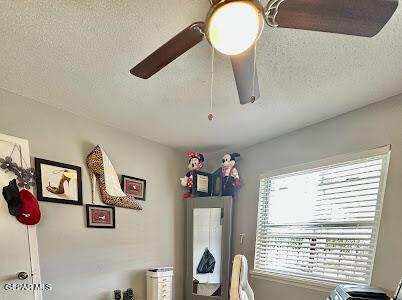 interior space with a ceiling fan and a textured ceiling