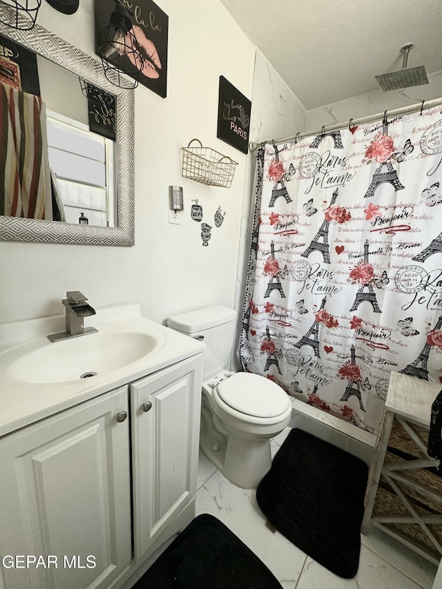 bathroom featuring marble finish floor, vanity, a shower with shower curtain, and toilet