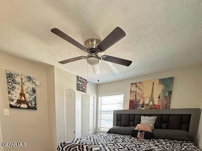 bedroom with a textured ceiling and ceiling fan