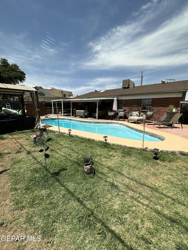 pool with a patio area, a lawn, and fence