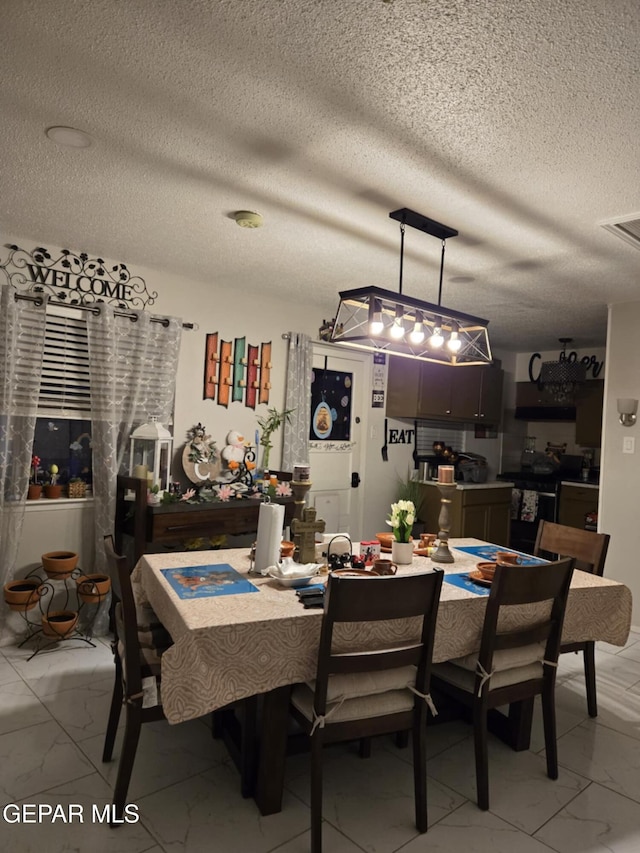 dining area featuring visible vents, a textured ceiling, and marble finish floor