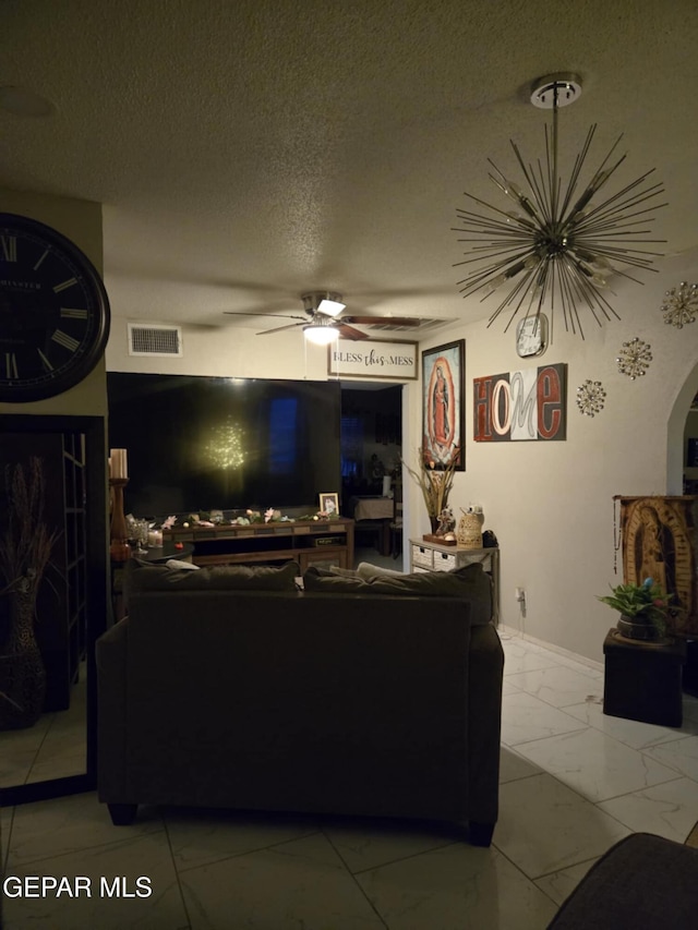 living room featuring baseboards, visible vents, ceiling fan, a textured ceiling, and marble finish floor