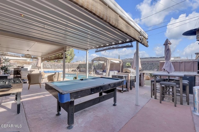 view of patio with outdoor dry bar, grilling area, an outdoor pool, and a fenced backyard