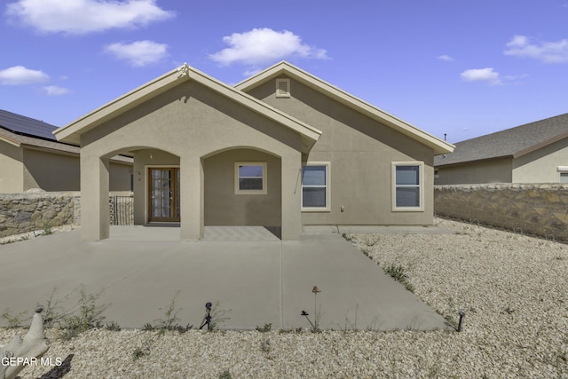 rear view of property featuring stucco siding