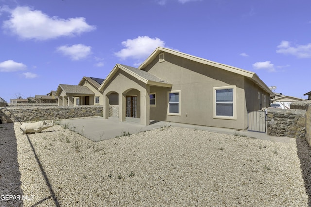 back of property featuring stucco siding, a patio, and fence