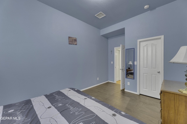 unfurnished bedroom featuring wood finished floors, visible vents, and baseboards