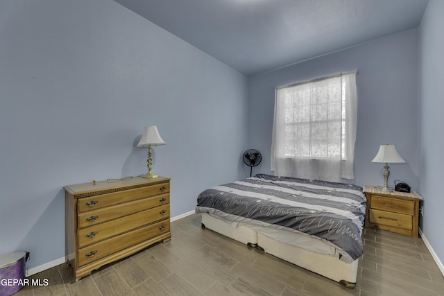 bedroom featuring wood finish floors and baseboards