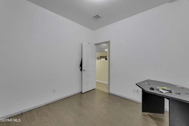 spare room featuring visible vents, baseboards, and wood finished floors