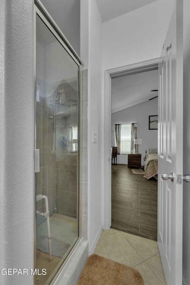 bathroom with lofted ceiling, a stall shower, tile patterned floors, and connected bathroom