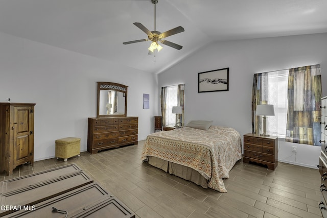 bedroom featuring multiple windows, a ceiling fan, lofted ceiling, and wood finish floors