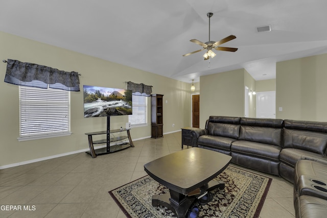 living area featuring light tile patterned flooring, plenty of natural light, baseboards, and lofted ceiling