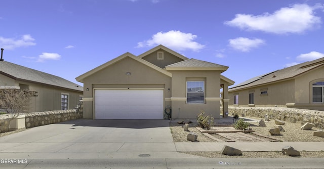 view of front of property with an attached garage, driveway, and stucco siding