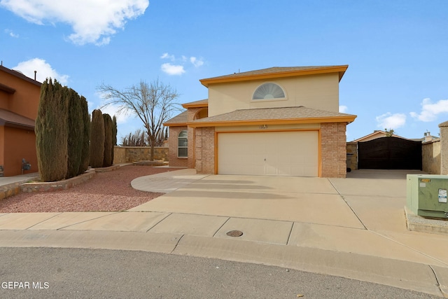 traditional home featuring brick siding, an attached garage, driveway, and a gate