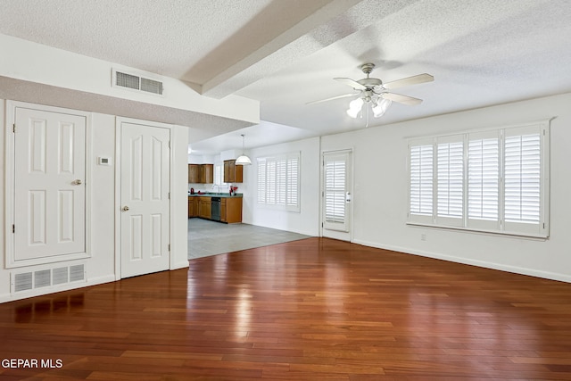 unfurnished living room with hardwood / wood-style floors, visible vents, and ceiling fan