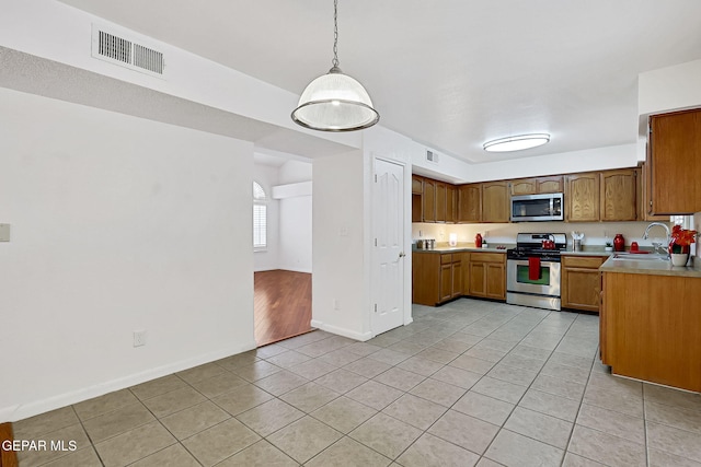 kitchen with light countertops, visible vents, appliances with stainless steel finishes, and a sink