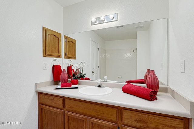 full bath with visible vents, walk in shower, and vanity