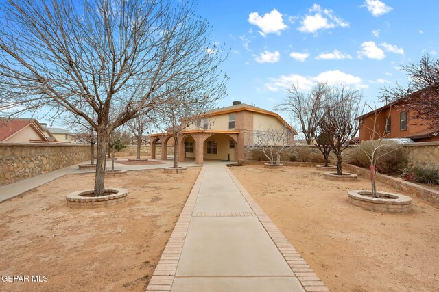 view of front of home featuring a patio area, stucco siding, and fence