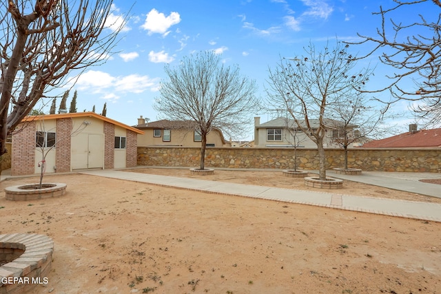 view of yard with an outbuilding, driveway, and fence