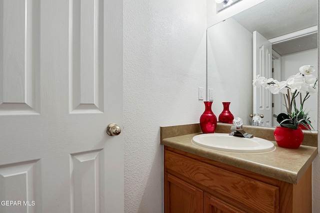 bathroom with vanity and a textured wall