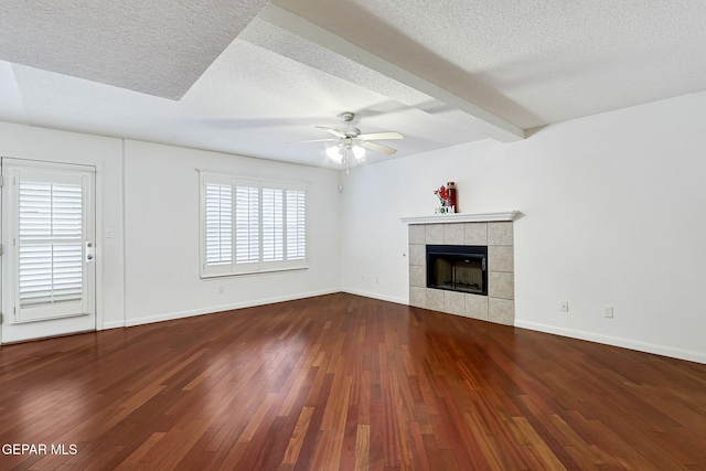 unfurnished living room featuring baseboards, hardwood / wood-style floors, a tile fireplace, a textured ceiling, and a ceiling fan