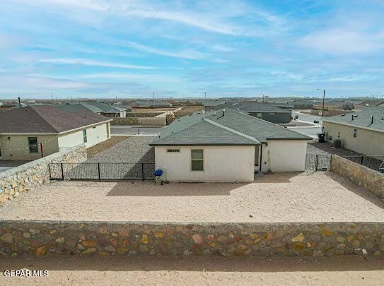 view of front of house featuring a residential view, a fenced backyard, and stucco siding